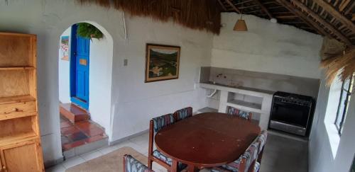 OvejeríaHacienda Yanahurco的一间设有桌子和蓝色门的用餐室