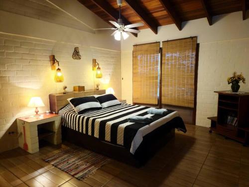 普库萨纳Casa de campo Villa Siles的一间卧室配有一张大床和吊扇