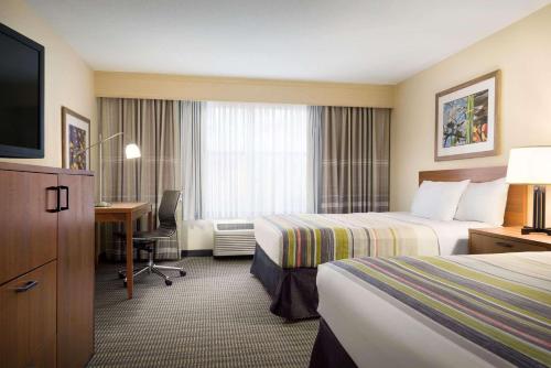 威廉斯堡威廉斯堡乡村酒店及套房的酒店客房配有两张床和一张书桌