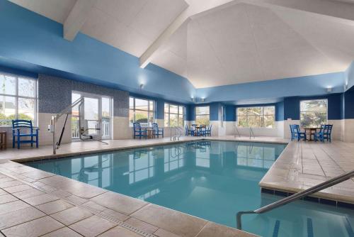 威廉斯堡威廉斯堡乡村酒店及套房的游泳池拥有蓝色的墙壁和蓝色的椅子