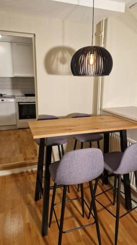 哥德堡Mysigt Stadsoas: En Modern lägenhet med 2 sovrum的餐桌、椅子和吊灯