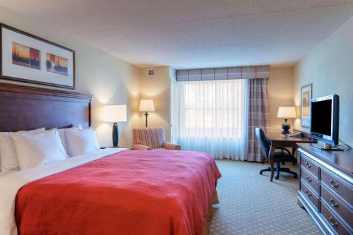 弗雷德里克斯堡Country Inn & Suites by Radisson, Fredericksburg, VA的酒店客房配有一张床和一张书桌及一台电视