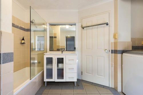 拜伦湾A Perfect Stay - Clarkes Beach Villa的一间带水槽、淋浴和镜子的浴室