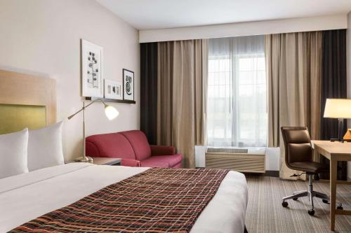 Schofield斯科菲尔德江山旅馆及套房的酒店客房配有一张床、一把椅子和一张书桌