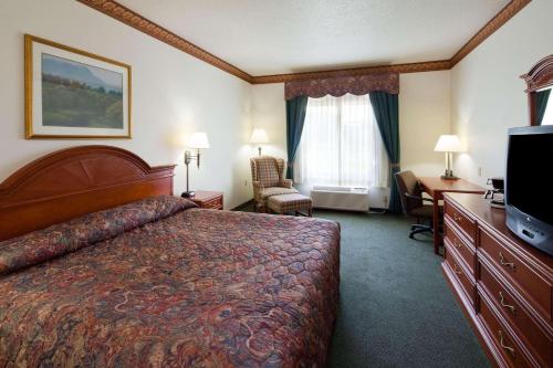 普雷里德欣Country Inn & Suites by Radisson, Prairie du Chien, WI的酒店客房配有一张床、一张书桌和一台电视。