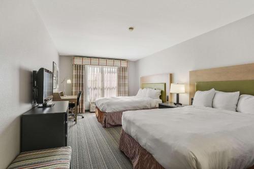 阿施瓦贝农Country Inn & Suites by Radisson, Green Bay, WI的酒店客房设有两张床和一台平面电视。
