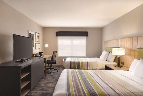 麦迪逊威斯康星州麦迪逊丽怡乡村套房酒店的酒店客房设有两张床和一台平面电视。