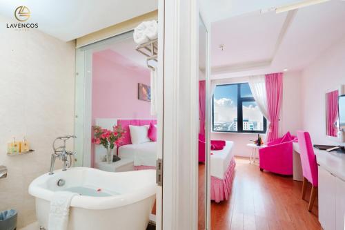 岘港Lavencos Hotel Da Nang的带浴缸的浴室和1间带1张床的卧室