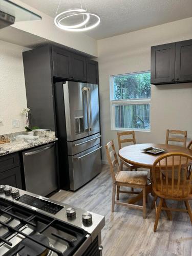 奥克兰Bumblebee House的一间带桌子的厨房和一间带冰箱的厨房