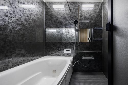 淡路Hotel Dios - Vacation STAY 40406v的设有带浴缸和淋浴的浴室。