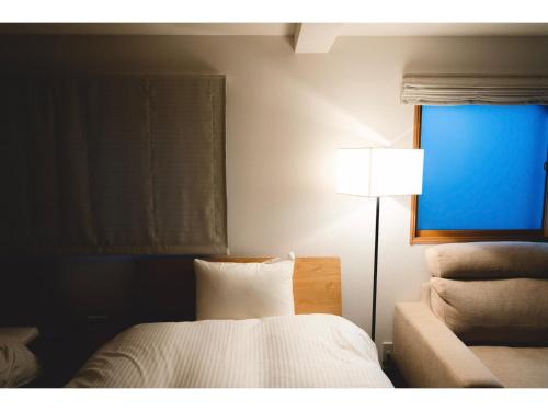 京都ＳＯ Ｋｙｏｔｏ Ｆｕｓｈｉｍｉ Ｉｎａｒｉ - Vacation STAY 76154v的一间卧室配有床、灯和窗户