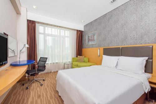 北京北京东直门智选假日酒店的配有一张床和一张书桌的酒店客房