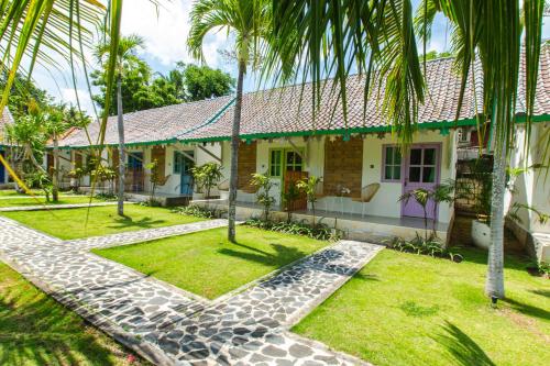 珀尼达岛La Roja Bungalows的前面有棕榈树的房子