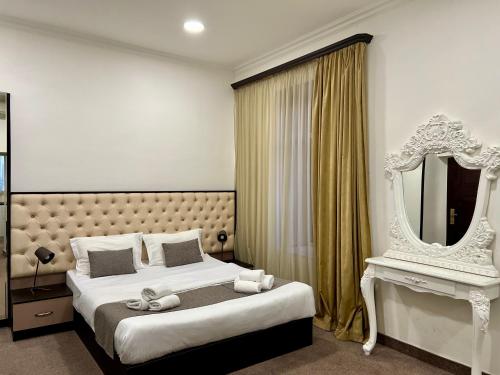 埃里温YVN Tumanyan apart-hotel的一间卧室配有一张大床和镜子