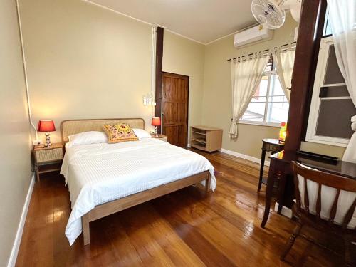 南府บ้านมาดามกรีน Baan Madamn Green Nan的卧室配有一张床、木地板和窗户。
