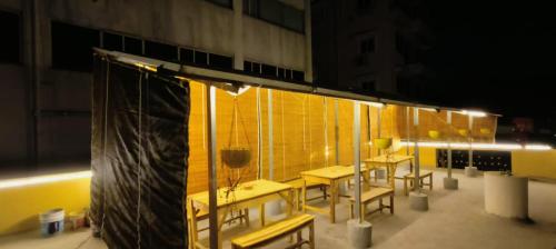 海得拉巴KyGo Hostels的一群桌子和椅子在晚上在阳台上