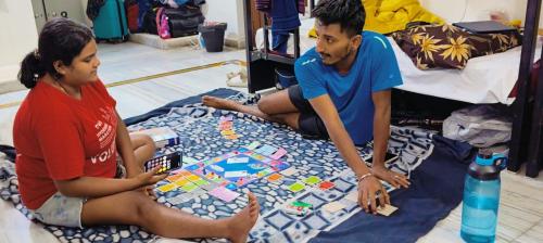 海得拉巴KyGo Hostels的两个人坐在地上玩棋盘游戏
