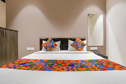 苏拉特FabExpress Ospite的床上有五颜六色的毯子