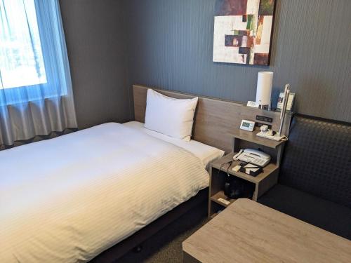 千叶HOTEL ROUTE-INN Chiba Hamano -Tokyowangan doro-的酒店客房带两张床和电话