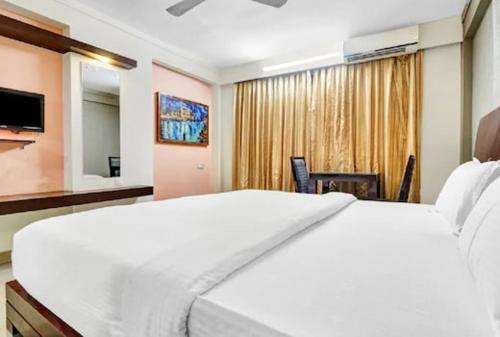 阿勒皮AEC Travel and Leisure Solution Pvt Ltd的卧室配有一张白色大床和电视。