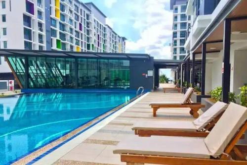 古晋Vivacity Megamall Jazz Suite Kuching 8pax 3BR #Joyoustayz的一座游泳池旁设有两把躺椅