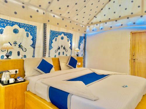 斋沙默尔Golden Fort Resort的一间卧室配有一张蓝色和白色装饰的大床