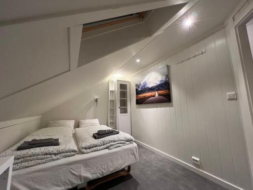 BirkenesOggevatn的卧室配有两张床,墙上挂着一幅画