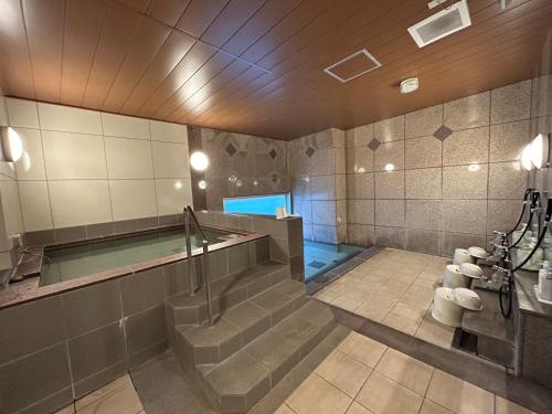 名古屋名古屋荣鲁泰因酒店的浴室设有游泳池和楼梯。