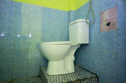 LubuklinggauOYO 2585 Sherren Guest House的蓝色瓷砖浴室内的白色卫生间