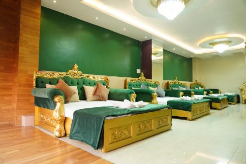 德奥加尔MAHARAJA DORMITORY的一间设有四张床和绿色墙壁的客房