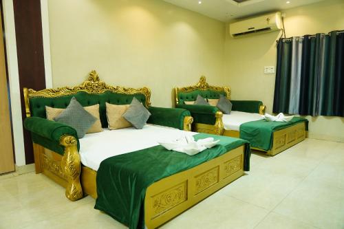 德奥加尔MAHARAJA DORMITORY的绿色和金色客房的两张床