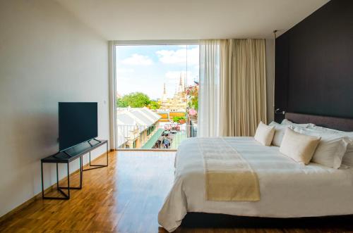 曼谷萨拉拉坦纳可心曼谷酒店的一间卧室设有一张大床和一个大窗户