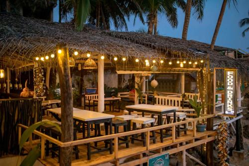高尔Oynise Beach Cabin的餐厅设有桌子和灯,并种植了棕榈树