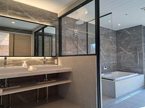 伊势市森之森住宿加早餐旅馆的浴室配有两个盥洗盆和浴缸。