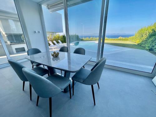 卡尼奥提Family villa SoFia 4 bedrooms的一间设有玻璃桌和椅子的用餐室