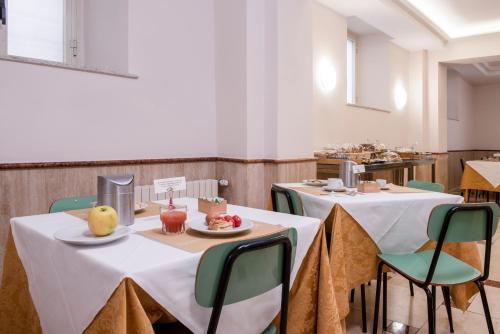 罗马Casa San Giuseppe的一间房间,配有两张桌子和椅子,并备有食物