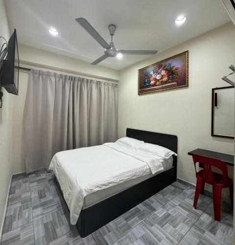 和丰西子楼 CZI Budget Hotel Sungai Siput的一间卧室配有一张床、一张桌子和吊扇