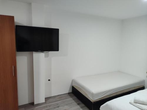 尼什Apartmani Hub的一间卧室配有一张床,墙上设有一台平面电视