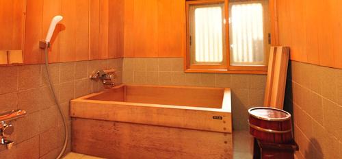 新发田市Ryokan Imai的带窗户的浴室内的木浴缸