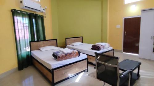 HārmutigāonHengdang Resort的配有椅子的客房内的两张床