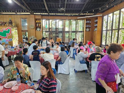 Ban Lam Thong LangBaan Rai Somkiat Homestay Saraburi的一群坐在餐厅桌子上的人