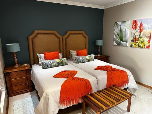 JwanengMeyers Guesthouse的一间卧室配有一张带橙色床单的大床