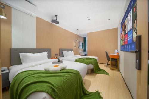 广州广州雅舍酒店（科韵路地铁站琶洲会展店）的酒店客房,配有三张床和绿毯