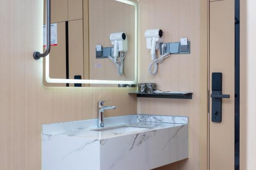 广州广州雅舍酒店（科韵路地铁站琶洲会展店）的一间带水槽和镜子的浴室