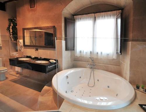Zarratón卡萨富尔特宫酒店的带浴缸和两个盥洗盆的大浴室