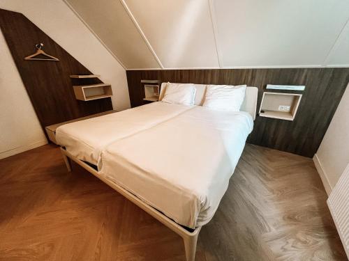 雷讷瑟Hotel de Zeeuwse Stromen - Duinpark的卧室配有一张带白色床单和枕头的大床。