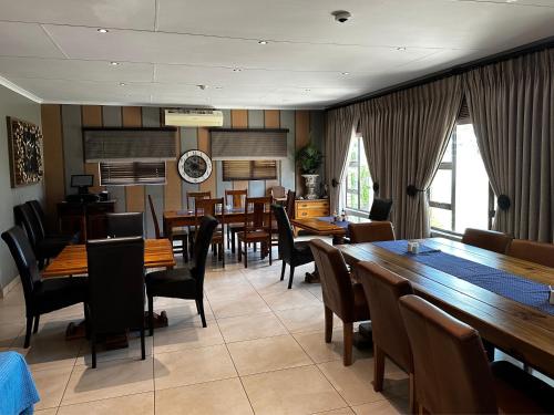 JwanengMeyers Guesthouse的用餐室配有木桌和椅子