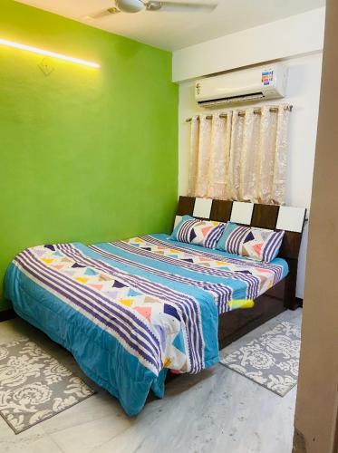 纳西克Aashiyana的一间拥有绿色墙壁的卧室,其中配有一张床