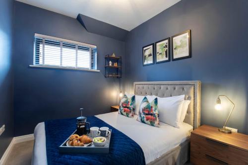 格洛斯特Elliot Oliver - Loft Style 2 Bedroom Apartment With Parking In The Docks的一间卧室配有一张床,上面放着一个食物托盘