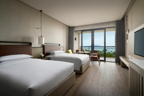 三亚三亚亚龙湾万豪度假酒店（2020年焕新升级·C位海景）的酒店客房设有两张床和电视。